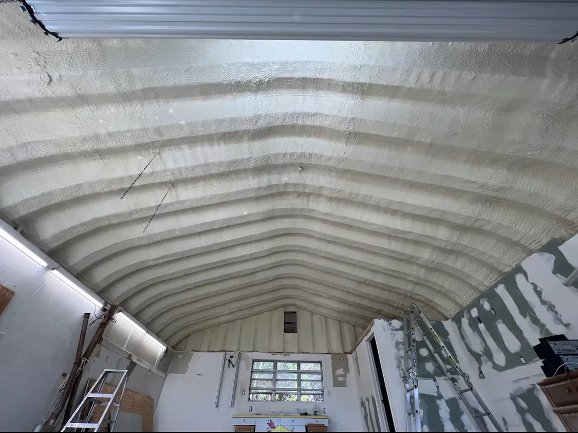 Spray polyurethane foam applied to the underside of a metal roof deck in Gladewater